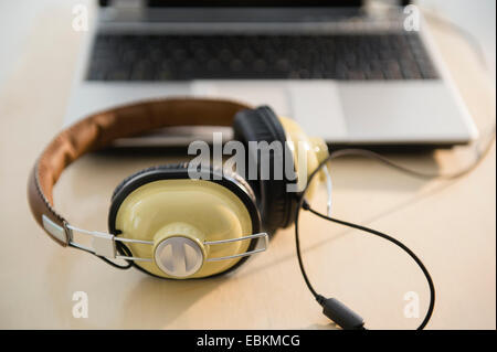 Kopfhörer und Laptop auf Tisch Stockfoto