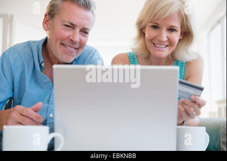 Porträt des Paares mit Laptop, mit Kreditkarte im Blick