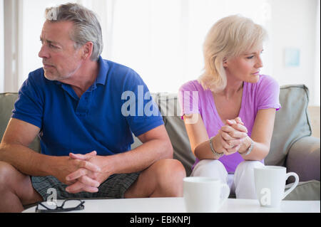 Porträt des Paares auf Sofa, auf der Suche von einander entfernt sitzen Stockfoto