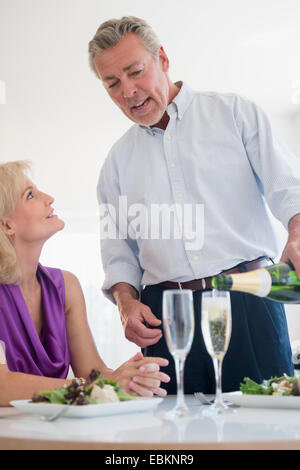 Porträt des Mannes Gießen Champagner am Tisch im restaurant Stockfoto