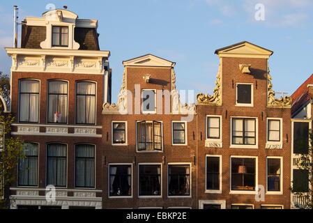Traditionelle Häuser reflektieren den Charme eines Kanals in Amsterdam während des späten Nachmittagslichts. Niederlande Stockfoto