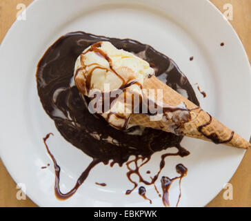 Studioaufnahme von Eis auf Teller mit Schokoladensauce Stockfoto