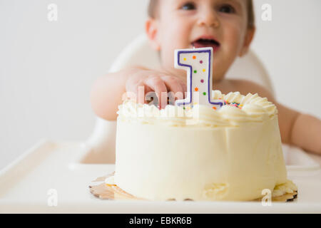 Studioaufnahme von Baby (12-17 Monate) für Kuchen zu erreichen Stockfoto