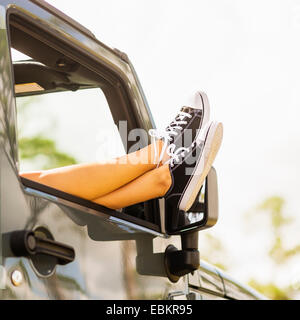 Frau halten Beine außerhalb Auto Stockfoto