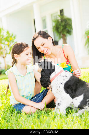 Mädchen (6-7) mit Mutter und Hund im Hinterhof, Jupiter, Florida, USA Stockfoto