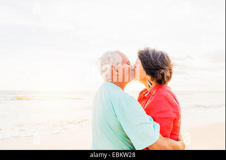 USA, Florida, Jupiter, älteres Paar küssen am Strand bei Sonnenaufgang Stockfoto