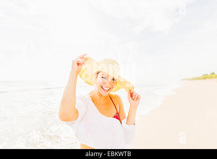 USA, Florida, Jupiter, Porträt der lächelnde junge Frau am Strand Sonne Hut Stockfoto