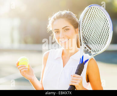 Porträt der jungen Frau mit Tennisball und Tennisschläger Stockfoto