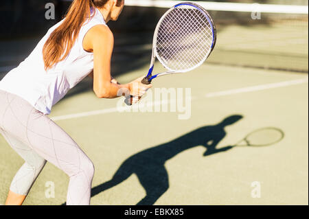 Hoch-Abschnitt Schuss der jungen Frau, die mit dem Tennisspielen im Freibad Stockfoto