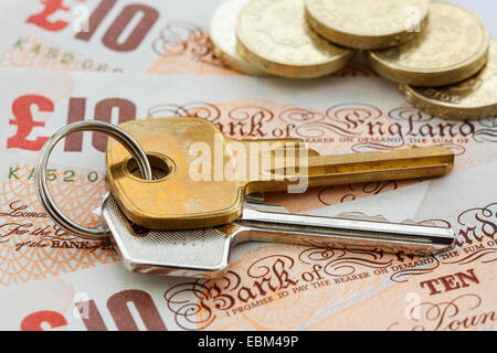 Haus Schlüssel auf Geld Sterling Scheine GBP mit Pfund-Münzen zu britischen Immobilienpreise Werte Hypothekenkosten Sparkonzept zu veranschaulichen. England Großbritannien Stockfoto