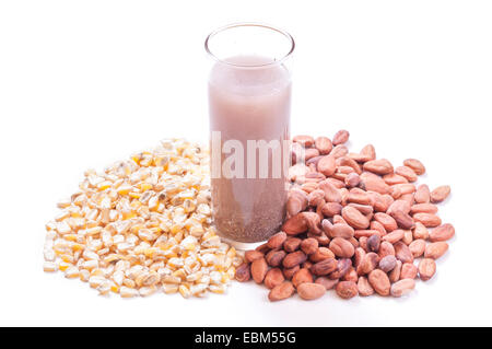 Longdrinkglas mexikanischen Pozol Getränk zwischen ganzen Kernel Mais und rohe Kakaobohnen auf weißem Hintergrund Stockfoto