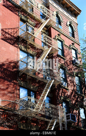 Manhattan New York USA - Feuerleiter auf einem alten roten Backsteingebäude, typisch für Greenwich West Village Stockfoto