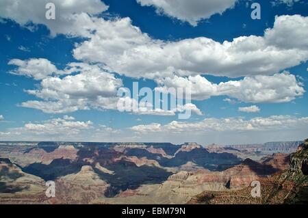 Flauschige Wolken und blauer Himmel werfen Schatten über den Grand Canyon, USA Stockfoto