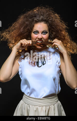 lustige Frau spielt mit ihren Haaren Stockfoto