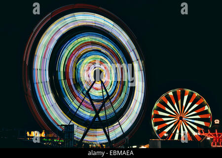 Lange Exposition der Riesenräder in der Nacht zu einem Karneval Stockfoto