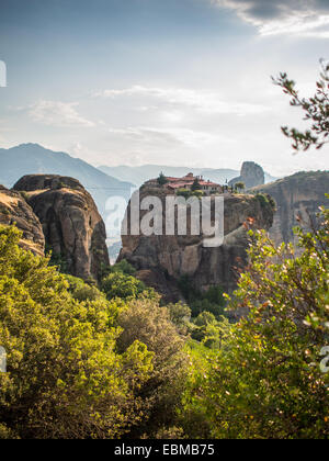 Kloster der Heiligen Dreifaltigkeit hinter den Büschen und oben auf den Felsen, Meteora Stockfoto