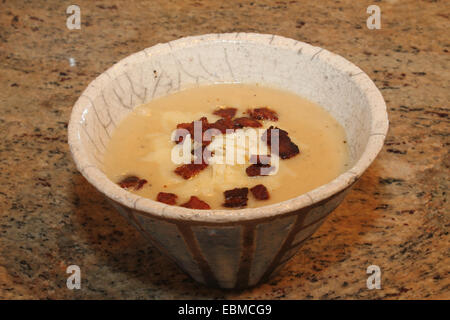 Horizontales Bild der hausgemachte Kartoffelsuppe mit Speck und weißer Cheddar-Käse in einem gestreiften, Steingut, kegelförmige Schale Stockfoto