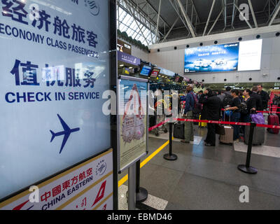 Passagiere mit Gepäck in der Schlange am Check-in Schalter am Flughafen Peking, China Stockfoto