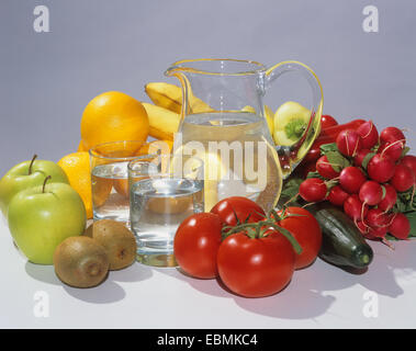 Glaskaraffe mit Wasser, zwei Gläser, Obst und Gemüse gefüllt Stockfoto