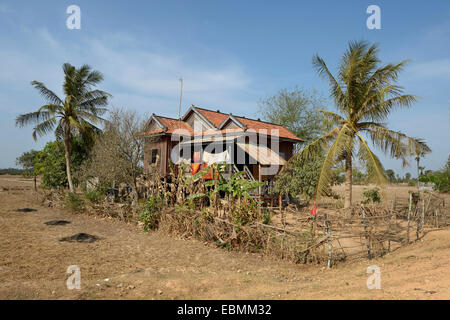 Traditionelles Haus auf Stelzen, umgeben von einem Garten mit Palmen Bäume, versaut District, originellen Provinz, Kambodscha Stockfoto