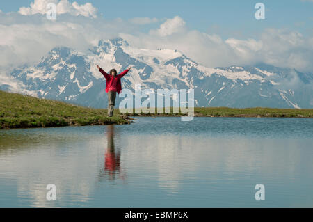 Der Tourist in rot gekleidet befindet sich in der Nähe von schönen Bergsee. Stockfoto