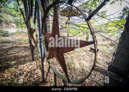 Roter Stern auf ein altes Tor in Chernobyl-2 Militärbasis neben sowjetischen Duga-3 Radar in der Sperrzone von Tschernobyl, Ukraine Stockfoto