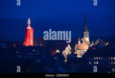 Nach der Eröffnung des Weihnachtsmarktes in Schlitz, Deutschland, 29. November 2014 ist die bekennende größte Kerze der Welt beleuchtet. Der 36 Meter hohe Turm auf dem historischen Marktplatz ist in rotes Tuch bedeckt. Auf ihrem Höhepunkt sind mehr als 110 Glühbirnen, angeordnet, um eine 6 Meter hohe Flamme ähneln. Foto: Arne Dedert/dpa Stockfoto