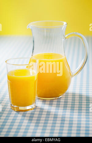 Ein Glas und Krug mit Orangensaft. Kurze Tiefenschärfe. Stockfoto