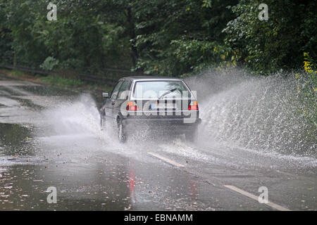 Straßenverkehr auf der überfluteten Straße bei starkem Regen, Deutschland Stockfoto