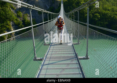 weibliche Wanderer auf Aussetzung Brücke über See Lac de Besitzer-Avignonet, Frankreich, Grenobl Stockfoto