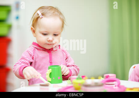 kleines Mädchen spielt Kaffee trinken mit Kunststoff-Spielzeug Stockfoto