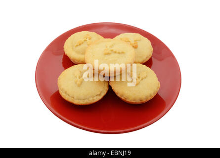 Fünf hausgemachte Mince Pies auf einem festlichen roten Teller, isoliert auf weißem Hintergrund Stockfoto