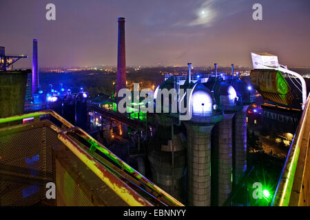 Blick vom Hochofen zum beleuchteten ehemaligen Hüttenwerk und Vollmond in der Nacht, Landschaftspark Duisburg-Nord, Deutschland, Nordrhein-Westfalen, Ruhrgebiet, Duisburg Stockfoto