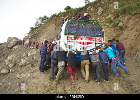 Leute, die einen Bus auf einer schlammigen Straße auf dem Weg nach Dhunche, Nepal Langtang Himal Stockfoto