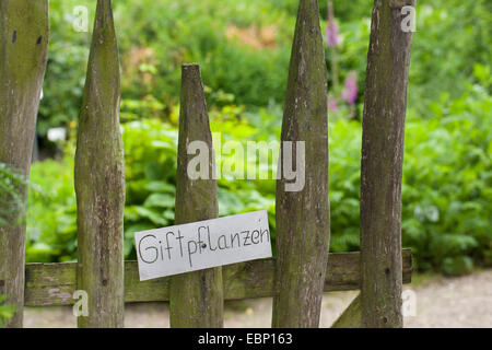 Schild am Eingang eines Gartens mit Pflanzen können Stockfoto