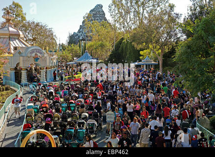 Menschen durch einen überfüllten Abschnitt von Fantasyland in der Nähe der kleinen Weltattraktion waten / Reiten in der glücklichste Ort auf der Erde. Stockfoto