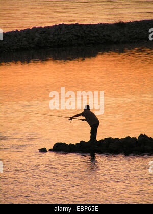 Angler in der Dämmerung / im Zwielicht Stockfoto