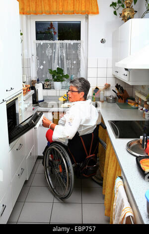 Rollstuhlfahrer in einer Behinderten zugänglich Küche Stockfoto