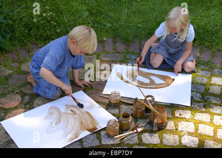 zwei Kinder malen mit Erde Farbe, Deutschland Stockfoto