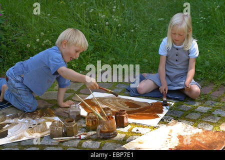 zwei Kinder malen mit Erde Farbe, Deutschland Stockfoto