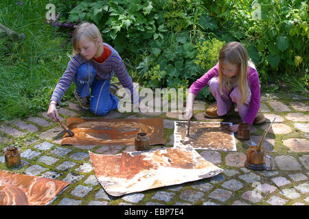 zwei Kinder malen mit Erde Farbe, Deutschland Stockfoto