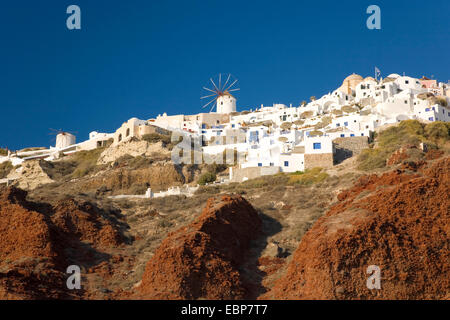 IA, Santorini, südliche Ägäis, Griechenland. Blick auf das Dorf von Ammoudi Bucht, Hügel Windmühle Prominente. Stockfoto