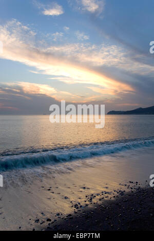 Vlychada, Santorini, südliche Ägäis, Griechenland. Bunten Abendhimmel spiegelt sich in den ruhigen Gewässern des das Meer von Kreta. Stockfoto