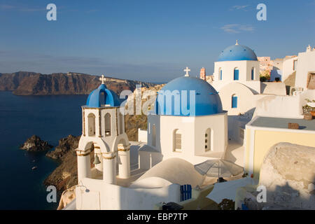 IA, Santorini, südliche Ägäis, Griechenland. Typische blaue Kuppel Kirchen festhalten an Hang über der Caldera. Stockfoto