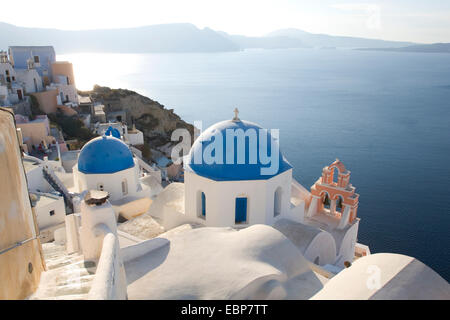 IA, Santorini, südliche Ägäis, Griechenland. Typische blaue Kuppel Kirchen festhalten an Hang über der Caldera. Stockfoto