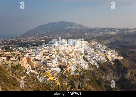 Fira, Santorini, südliche Ägäis, Griechenland. Die Klippe Stadt bei Sonnenuntergang, Profitis Ilias, der höchsten der Insel zeigen, darüber hinaus sichtbar. Stockfoto