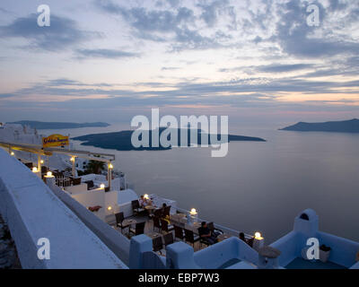 Firostefani, Santorin, südliche Ägäis, Griechenland. Blick über die Caldera in der Abenddämmerung, die vulkanische Insel von Nea Kameni Prominente. Stockfoto