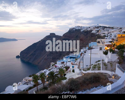 Firostefani, Santorin, südliche Ägäis, Griechenland. Blick entlang der Caldera-Rand in der Dämmerung, dem Felsvorsprung von Skaros Prominente. Stockfoto