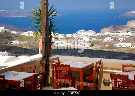 Pyrgos, Santorini, südliche Ägäis, Griechenland. Blick über die Caldera von Terrasse eine typische Taverne, Kreuzfahrtschiff im Hafen. Stockfoto