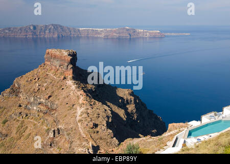 Imerovigli, Santorin, südliche Ägäis, Griechenland. Blick von der Klippe auf Skaros Rock und der fernen Insel Thirasia. Stockfoto